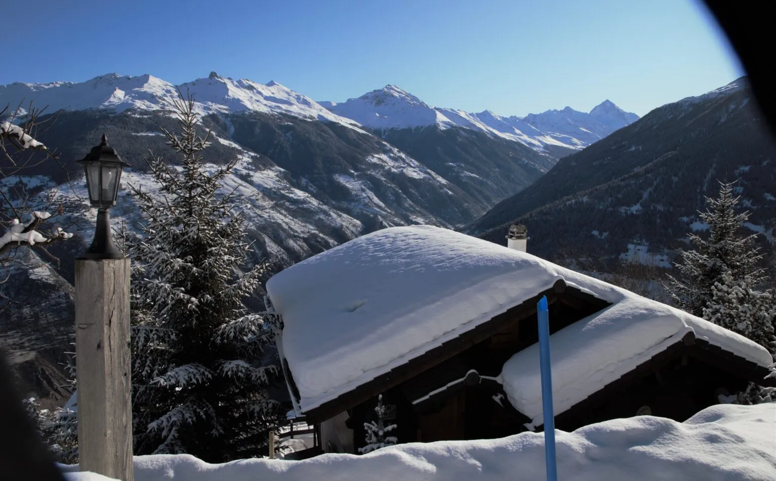 Toit de chalet enneigé face aux montagnes en hiver